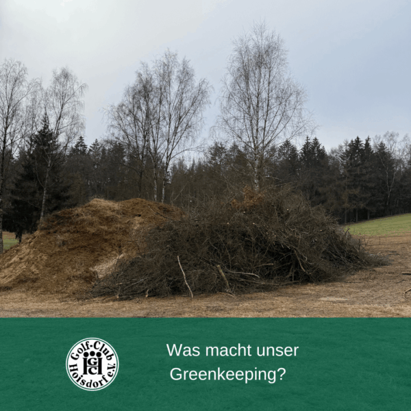 Ein großer Haufen aus Erde und Zweigen liegt auf einer Wiese vor einer Reihe von kahlen Bäumen. Unten ist ein grüner Balken mit dem Logo des Golf-Clubs Feldafing und dem Text "Was macht unser Greenkeeping?".